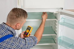 技术人员用万用表检查冰箱