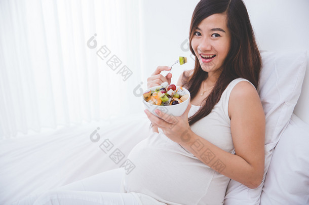 一碗水果，美丽的孕妇白色背景