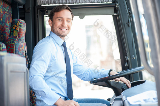 Attractive young man is driving a public transport