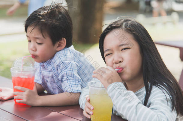 可爱的亚洲孩子饮用<strong>鲜榨果汁</strong>