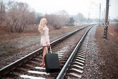 女人带的行李上铁路公路行走的后视图