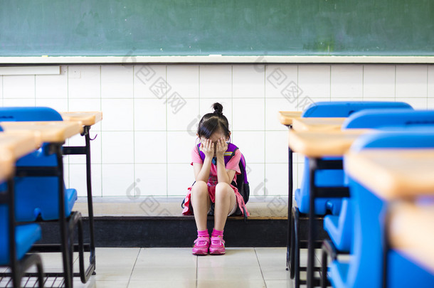 强调坐在女孩与思考教室地板