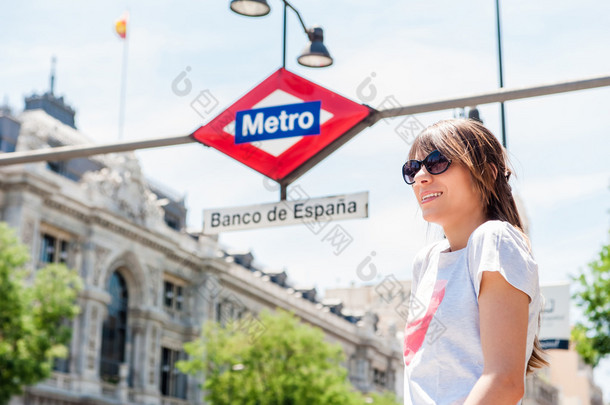 Young tourist woman in front of Madrid, Banco de Espana metro station.