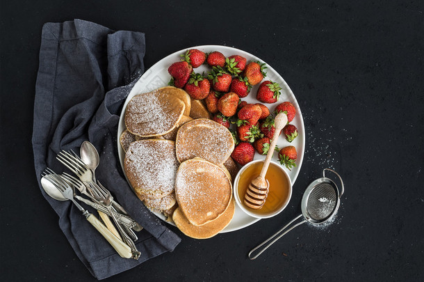 Breakfast plate. Homemade pancakes with fresh strawberry and honey, kitchen napkin, vintage silverwa