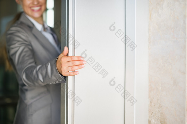 持有电梯<strong>门</strong>的业务的女人手上的特写