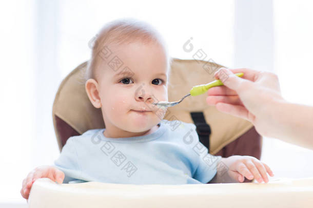 孩子从一个勺子吃吃牛奶粥