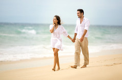 浪漫的情侣在沙滩上行走