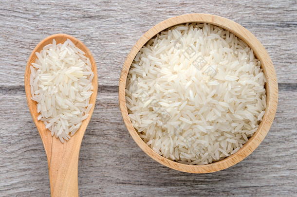 生的米在碗上白色木背景
