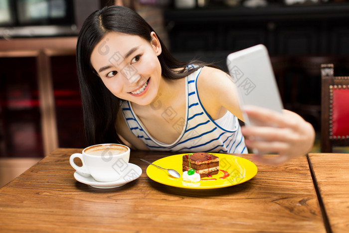 在咖啡馆店发短信在手机上的女孩