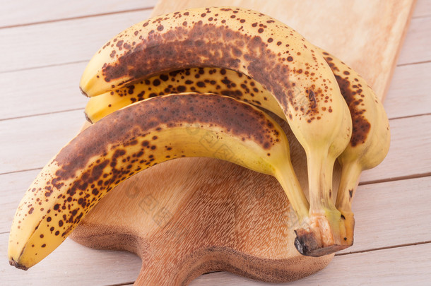 一群在木砧板上非常成熟的有机香蕉