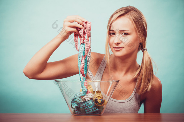 饮食。在碗里的彩色测量胶带的女孩