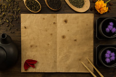 black, Oolong in a spoon, dried apples on the old blank open book on wooden background. Menu, recipe