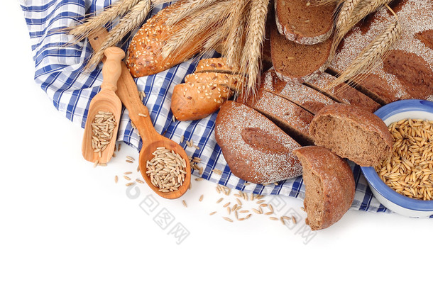 新鲜的面包，耳朵和粮食蓝色方格餐巾布上一个白色的背景，以及放置文本的位置.