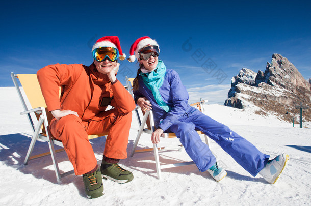 在山顶上玩两个滑雪板坐在椅子上躺椅在<strong>圣诞老人</strong>的<strong>帽子</strong>