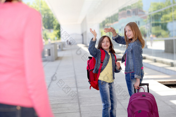 女学生在他们的妈妈挥手道别