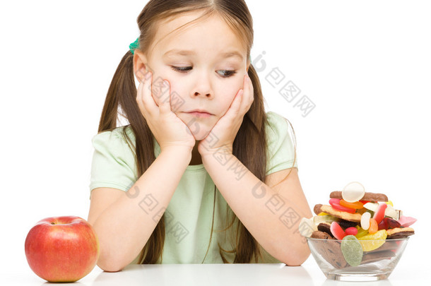 小女孩苹果和糖果之间选择