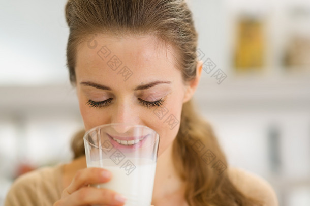 年轻女子在厨房里喝<strong>牛奶</strong>
