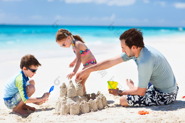 父亲和孩子们在海滩上嬉戏玩耍