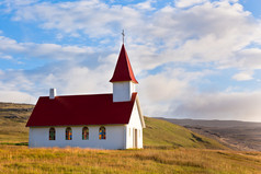 典型的冰岛乡村教堂在蓝色的夏日天空下
