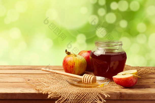 蜂蜜和散景花园背景木桌上的苹果