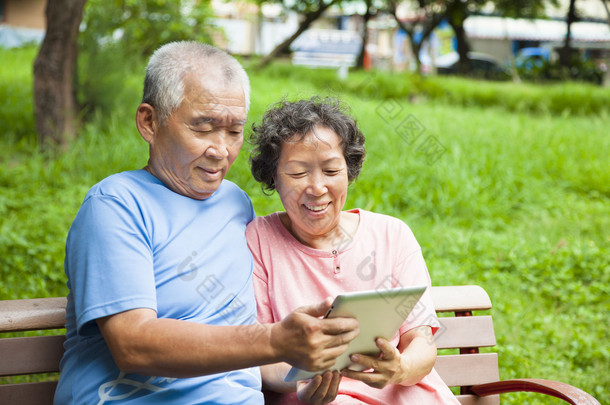 快乐老人<strong>夫妇</strong>与 tablet pc 在公园