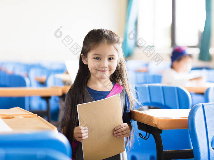 快乐的小女孩学生在教室里 学习书桌