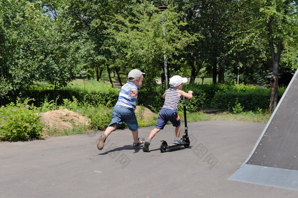 两个年轻男孩玩滑板车