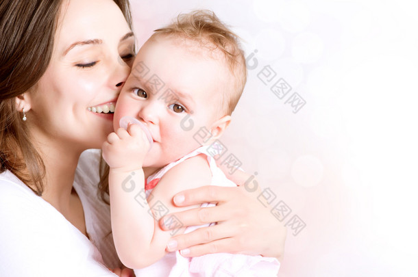 母亲和婴儿亲吻和拥抱。快乐的家庭