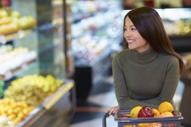 年轻的亚裔女子，在超市<strong>购物</strong>