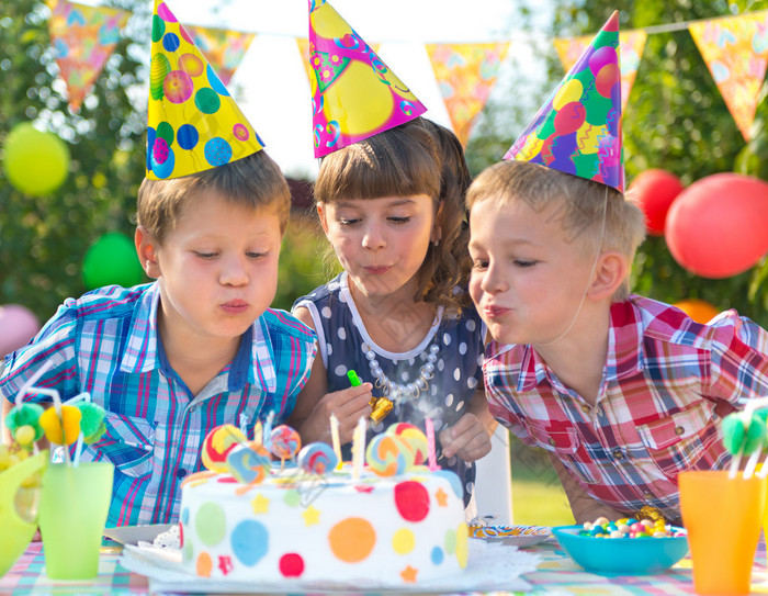 孩子们在生日蛋糕上吹蜡烛