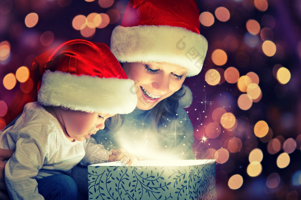 圣诞魔术礼品盒和快乐的家庭母亲和婴儿