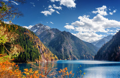 山脉和秋天树林之间长湖的美丽景色