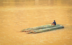 竹筏和一个男孩在河里漂浮