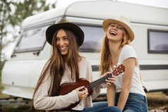 两个女孩微笑支持在一辆面包车.