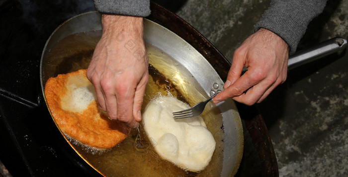 两个大煎饼蘸在热油中的铝壶 油锅