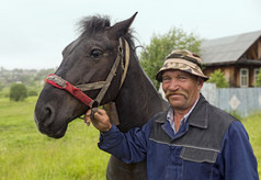 一位老农与他在雨中的马。老信徒村庄 Visim 俄罗斯.