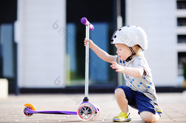 蹒跚学步的小男孩学骑<strong>滑板车</strong> 