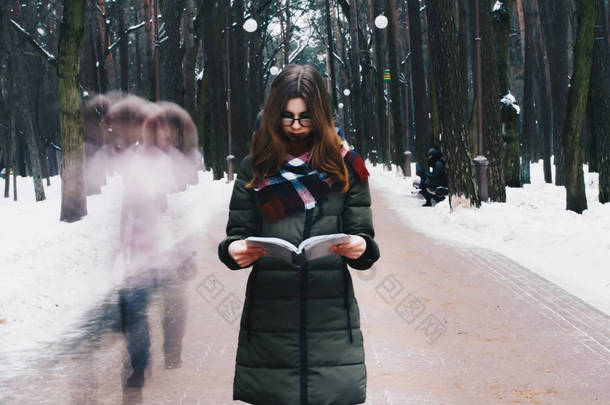 一个美丽的年轻女孩与眼镜，红色的嘴唇，一件夹克，一条围巾在肖像绑在脖子看书