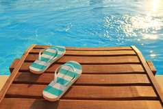 拖鞋上木日光浴浴床和水