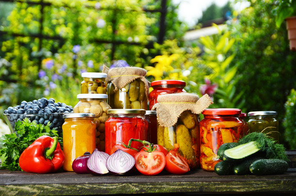 jars 的腌制蔬菜在花园里。腌制的食品