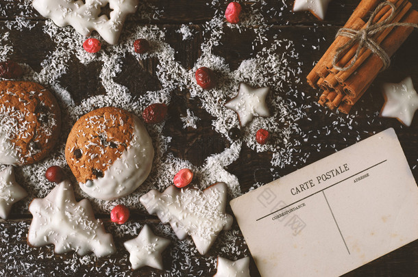 圣诞饼干与明信片和肉桂的木制的背景