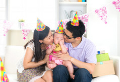 亚洲的中国父母亲吻孩子在生日聚会上