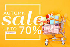 带明亮橙色背景的购物车的顶部视图，秋季销售，高达70%的插图 