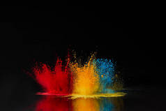 红色, 蓝色和黄色洒在黑色, 印度教春节的粉末爆炸