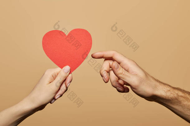 被剪下的照片上，一个女人拿着红心，另一个男人用米色与它隔离。