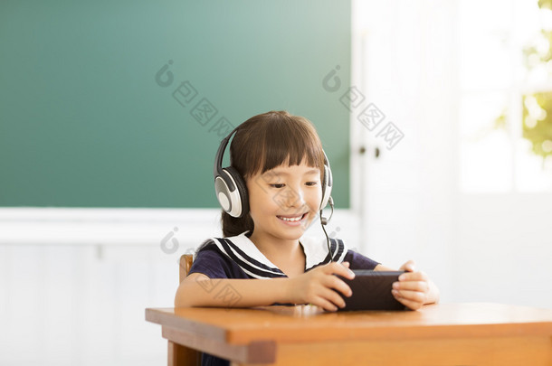 快乐<strong>的</strong>小女孩，与智能手机在教室里学习