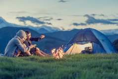 三个朋友在日落时分与火山上露营