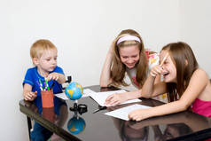 快乐的孩子在家里在桌子上学习