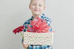 小男孩与红色的花及礼品盒
