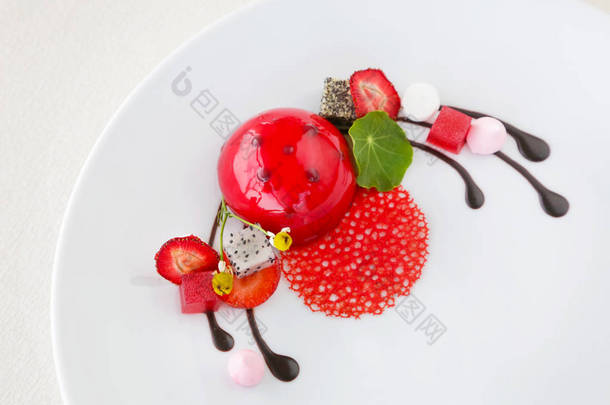 用草莓和可食用的花朵装饰的甜心红色甜点